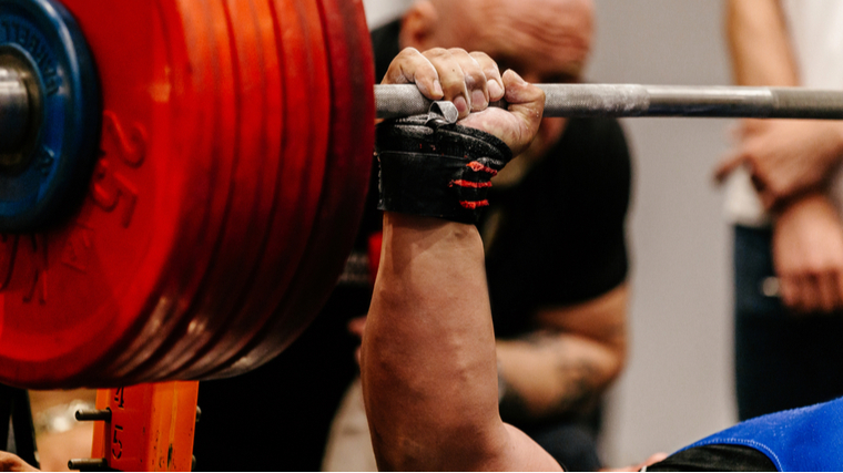 Hand holding a barbell loaded with very heavy weights