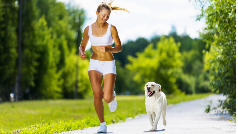 Woman jogging outdoors with dog