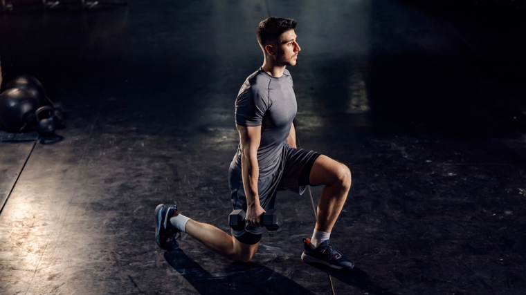 Man performing dumbbell lunge exercise
