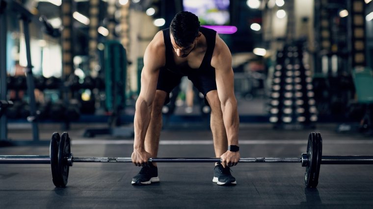 Man preparing to lift barbell from floor