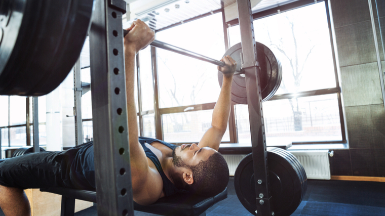 Man in gym performing bench press exercise